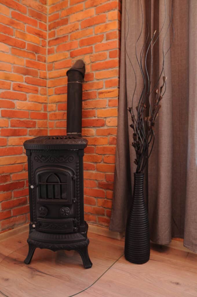 Płytki ceglane ze starych cegieł na ścianie w kolorze pomarańczowy na ścianie z czarną kozą 